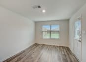 Thumbnail 40 of 46 - an empty living room with wood floors and a window