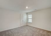 Thumbnail 43 of 46 - an empty living room with carpet and a white door