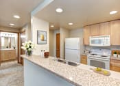 Thumbnail 2 of 15 - a kitchen with white appliances and wooden cabinets