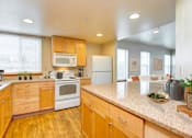 Thumbnail 3 of 15 - a kitchen with white appliances and wooden cabinets