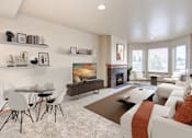Thumbnail 4 of 15 - a living room with white couches and chairs and a coffee table in front of a fireplace