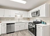 Thumbnail 1 of 28 - Renovated apartment kitchen with white cabinets and stainless steel appliances in Hattiesburg, MS