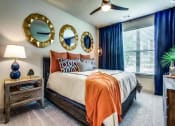 Thumbnail 5 of 18 - Grant Prairie TX Apartments- Spacious Bedroom With Cozy Gray Carpets, Stylish Ceiling Fan, and Large Open Window