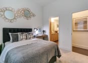 Thumbnail 11 of 40 - One Bedroom Apartments in Rowlett TX - Village of Rowlett - Bedroom with Plush Carpeting and an Attached Bathroom