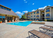 Thumbnail 16 of 22 - Swimming pool at Oak hollow with beach chairs and exterior building