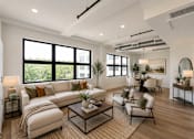 Thumbnail 3 of 25 - A well-lit, modern living room with a large window and a variety of furniture.