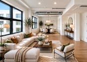 Thumbnail 6 of 25 - A well-lit, modern living room with a large white sofa and a coffee table.