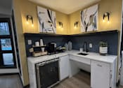 Thumbnail 28 of 29 - A kitchen with a white counter and a black oven.
