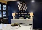 Thumbnail 22 of 29 - A reception area with a counter and a sign that says Remington Place.