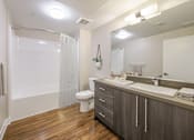 Thumbnail 10 of 18 - A bathroom with a toilet, sink, and mirror.