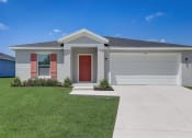 Thumbnail 3 of 29 - Houses in Lady Lake for Rent – The Groves at Lake Ella - a grey house with a red door and a lawn