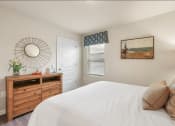Thumbnail 13 of 30 - a bedroom with a bed and a dresser with a mirror