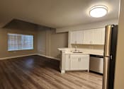 Thumbnail 2 of 16 - A kitchen with white cabinets and a black refrigerator.