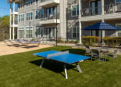 Thumbnail 25 of 40 - a ping pong table and chairs in front of an apartment building