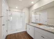 Thumbnail 23 of 30 - a white bathroom with two sinks and a shower
