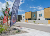 Thumbnail 18 of 20 - A row of modern townhouses with a banner that reads "VILLAS AT 91ST REM".