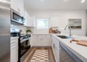 Thumbnail 3 of 20 - A kitchen with white cabinets and a checkered floor.