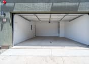 Thumbnail 15 of 20 - A garage with a white interior and a red light on the left side.