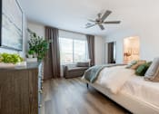 Thumbnail 6 of 20 - A bedroom with a large bed and a ceiling fan.