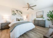 Thumbnail 7 of 20 - A bedroom with a large bed, a dresser, and a ceiling fan.