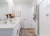 Thumbnail 8 of 20 - A bathroom with a white sink and a white door.