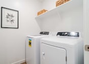 Thumbnail 14 of 20 - A small laundry room with a washer and dryer.