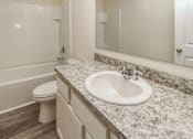 Thumbnail 34 of 38 - A bathroom with a marble countertop and a white sink.