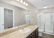 Thumbnail 25 of 63 - A bathroom with a sink, mirror, and shower.