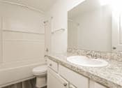 Thumbnail 34 of 75 - A white bathroom with a sink, toilet, and bathtub.