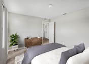 Thumbnail 23 of 63 - A bedroom with a bed, nightstand, and a plant.