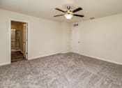 Thumbnail 33 of 38 - A room with a ceiling fan and carpeted floor.