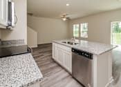 Thumbnail 29 of 38 - A modern kitchen with a granite countertop and stainless steel appliances.