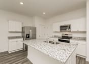 Thumbnail 30 of 75 - A kitchen with granite countertops and stainless steel appliances.