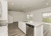 Thumbnail 27 of 75 - A modern kitchen with a stainless steel dishwasher and a ceiling fan.