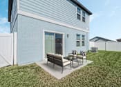 Thumbnail 4 of 63 - A blue house with a white fence and a patio with a table and chairs.