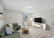 Thumbnail 16 of 63 - A living room with a green couch, a coffee table, and a television.