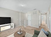 Thumbnail 15 of 63 - A living room with a television and a couch.