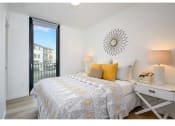 Thumbnail 15 of 54 - Apartments in Seattle - Inspire Fremont - Bedroom with Hardwood Style Flooring, Glass Door to Private Balcony/Patio, and Overhead Lighting