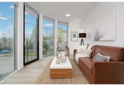 Thumbnail 17 of 54 - Apartments in Seattle for Rent - Inspire Fremont - Living Room with Hardwood Style Flooring, Glass Door to Private Balcony/Patio, Floor to Ceiling Windows, Overhead Lighting, and Stylish Decor