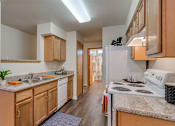 Thumbnail 21 of 47 - Apartments Spokane WA - Canyon Bluffs - Fully Equipped Kitchen with Granite Countertops and White Appliances