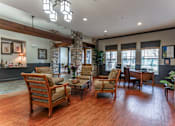 Thumbnail 1 of 13 - A living room with wooden floors and furniture.