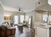Thumbnail 5 of 33 - A living room with wood floors and ceiling fan and windows and couch