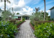 Thumbnail 16 of 19 - a pathway leading to a house with plants and trees