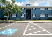 Thumbnail 18 of 19 - a blue building with a parking lot and a tree in front of it