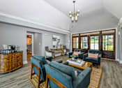 Thumbnail 12 of 17 - A living room with a wooden cabinet and blue couches.