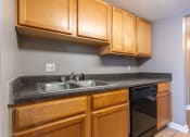 Thumbnail 11 of 29 - Westchase Apartments in Harvey LA photo of kitchen with black appliances and oak cabinets