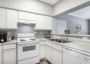 Thumbnail 5 of 39 - A white kitchen with a stove, sink, and refrigerator.
