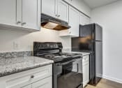 Thumbnail 2 of 33 - Whitney Manor Apartments in Gretna, LA photo of kitchen with black appliances and grey cabinets