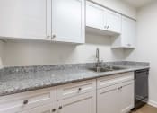 Thumbnail 26 of 33 - a kitchen with white cabinets and granite counter tops and a sink
