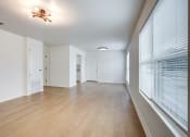 Thumbnail 4 of 33 - Whitney Manor Apartments in Gretna, LA photo of  an empty living room with a large window and wood flooring
